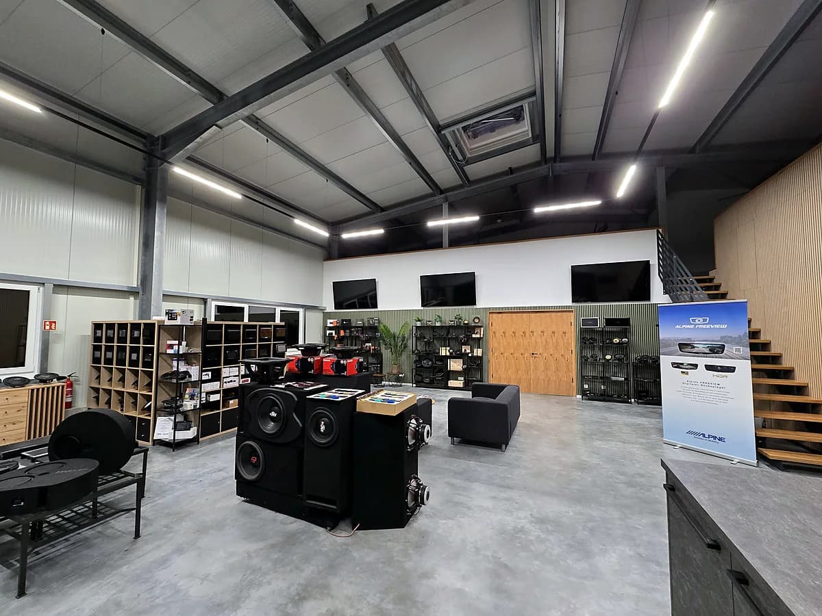 Showroom mit Subwoofer-Ausstellung, Komponenten-Regalen und Lounge-Ecke